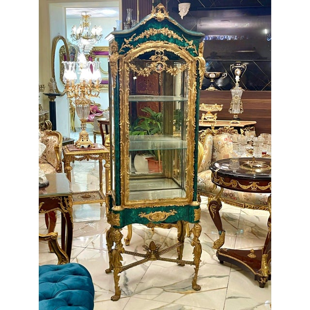 This magnificent French Louis XVI style vitrine features an elegant green finish beautifully accented with lavish gold...