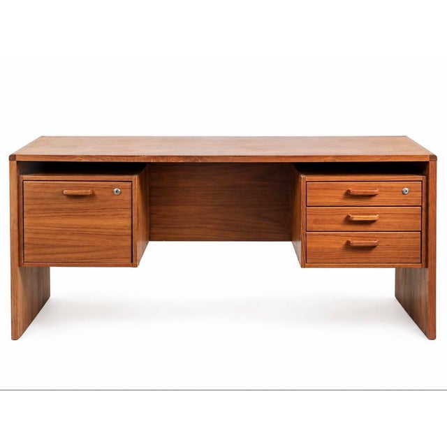 Vintage mid-century modern executive desk featuring a warm teak-toned wood finish, clean architectural lines, and a...