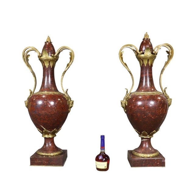 Elevate your interior to true palace-level grandeur with this exceptional pair of palatial-sized rouge marble and gilt...