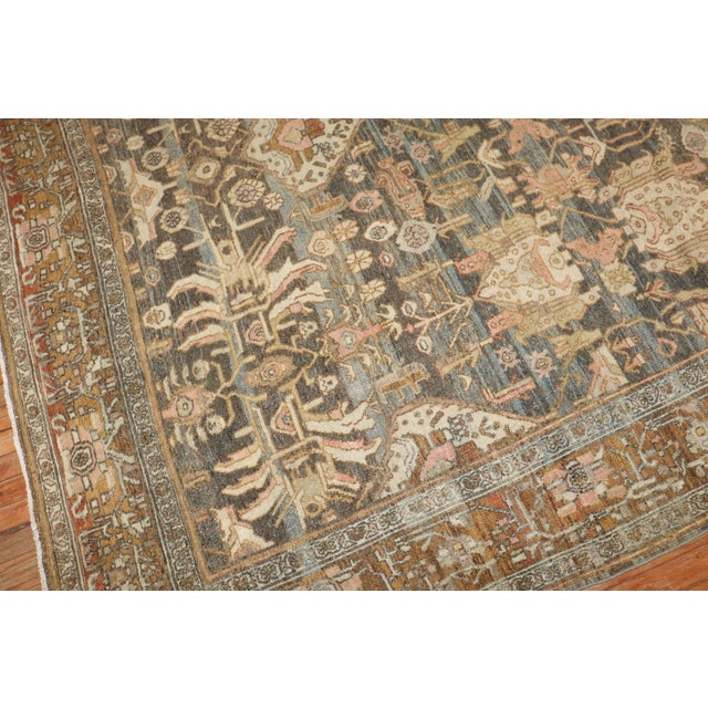 an early 20th Century Persian Bibikabad room-size rug in predominantly warm tones including accents in soft pink Measures:...