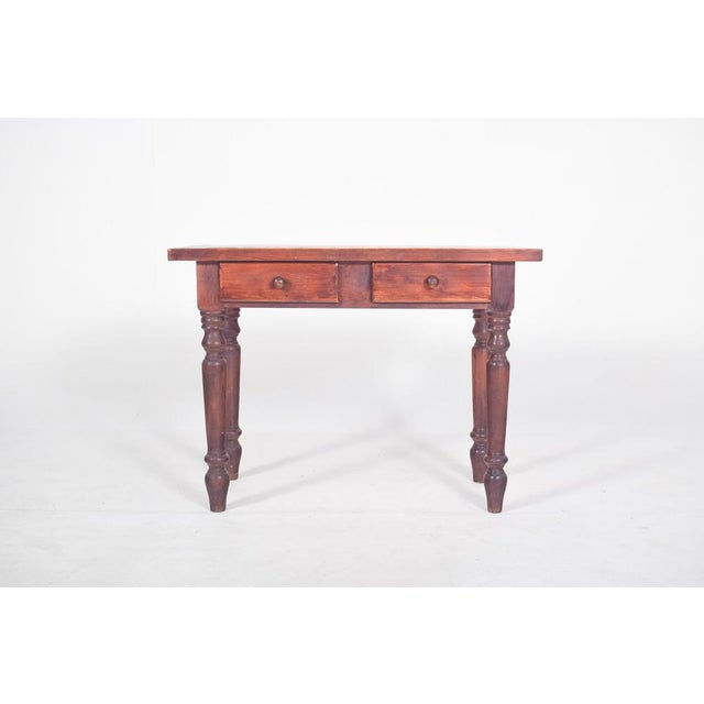 Pine kitchen table. With a flat rectangular top, simple edges and a sturdy structure, it is made up of four turned legs...