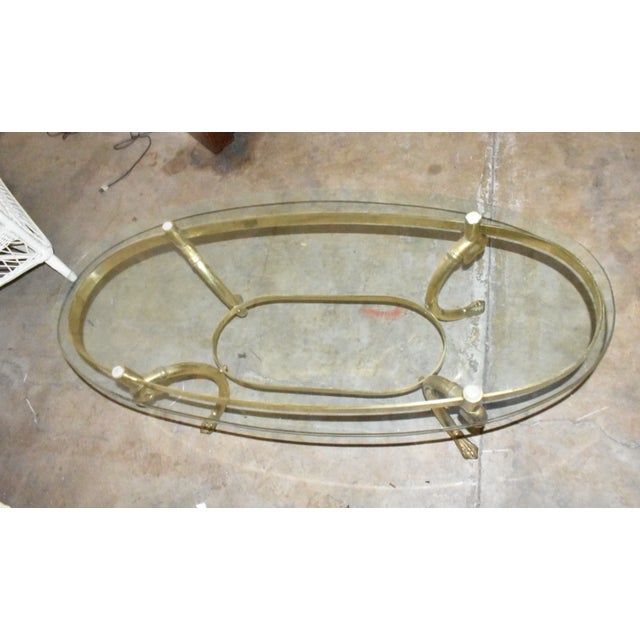 Add timeless elegance to your living space with this striking vintage Hollywood Regency brass and glass coffee table,...
