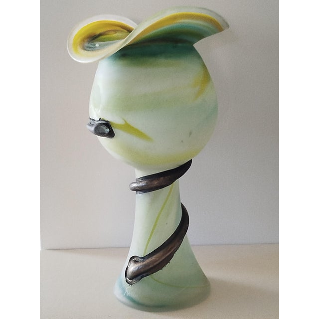 A sculptural, chalice-shaped vase, entirely handmade and mouth-blown, with a cloudy, aquamarine and sunny yellow hue....