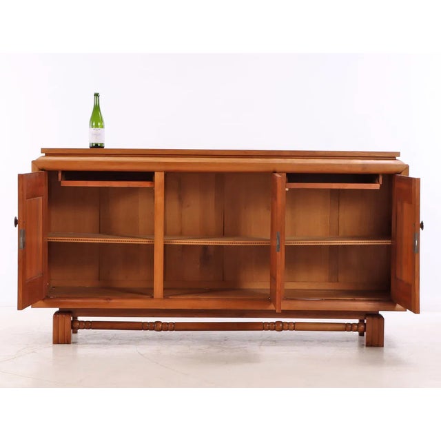 A bold and elegant French Art Deco Sideboard circa 1935 made of sycamore wood featuring striking stylized fruit-carving...