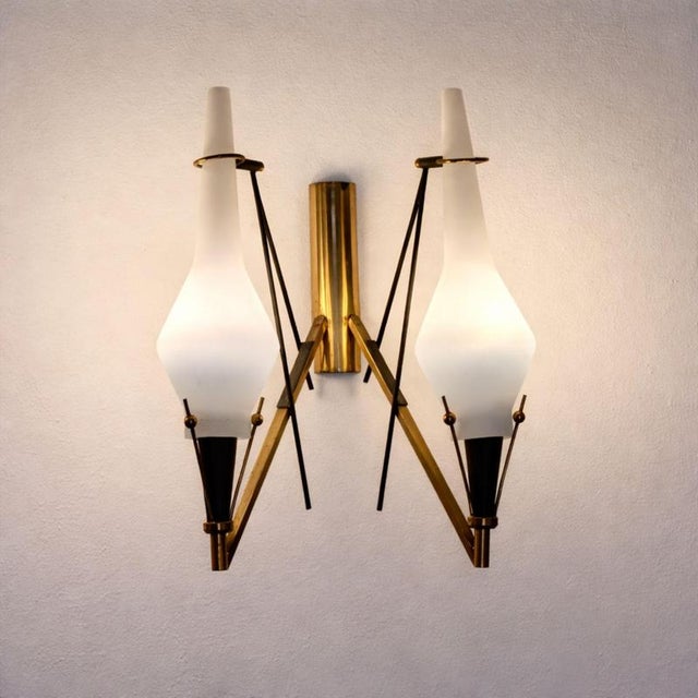 This set of three wall sconces was made in Italy in the 1960s and features a period-defining design, clearly inspired by...