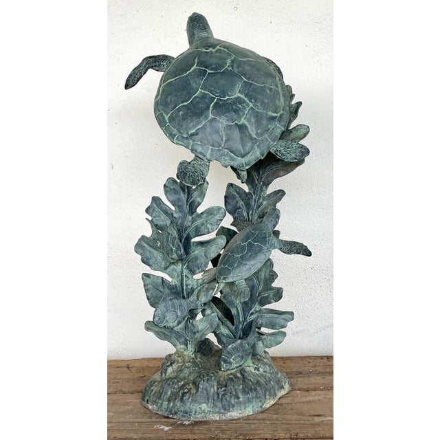 This captivating vintage sculpture celebrates the serene beauty of marine life with a dynamic composition of sea turtles...
