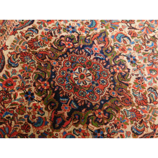 Vintage Persian rug. Rich in tone. Wool pile on cotton foundation. Floral pattern with intricate central medallion.