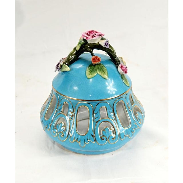 A highly decorative porcelain lidded urn in the Sevres style, richly adorned with a vibrant turquoise ground and detailed...