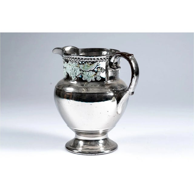 Antique early 19th century English Regency silver luster water pitcher with a band of relief molded grape vine decoration....