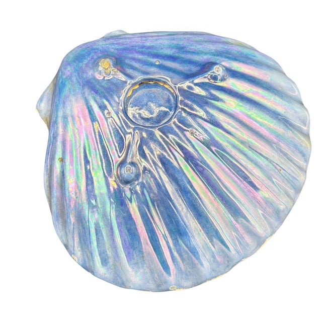 Mid-century rainbow iridescent blue clam shell ceramic ashtray. The ashtray features a calm shell shape with a white gloss...