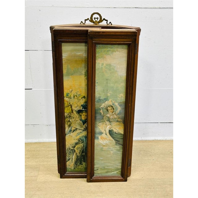 An elegant antique three-panel folding fireplace screen, likely dating to the late 19th century, featuring a continuous...