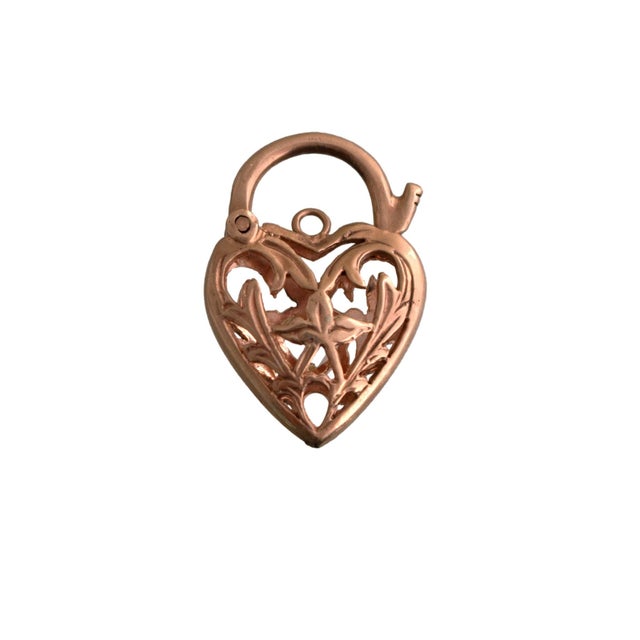 A vintage heart-shaped charm. Crafted from 9k rose gold, it features intricate leaf detailing. At its center, a heart-cut...