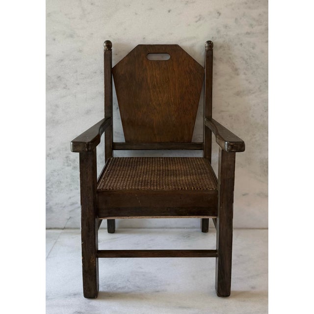 Vintage wood child's chair in an Arts and Crafts or Mission style design featuring a dark stain, geometric backrest panel...