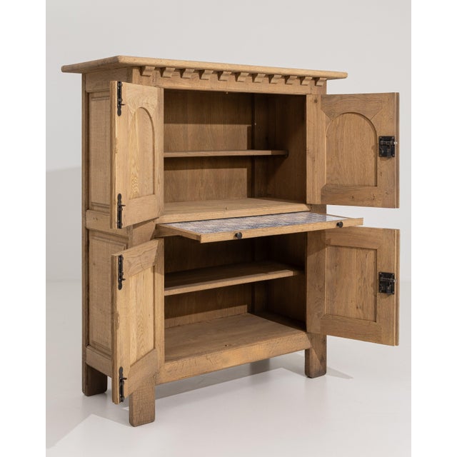 A bold Brutalist cabinet crafted in solid oak, showcasing strong geometric forms and textured surfaces characteristic of...
