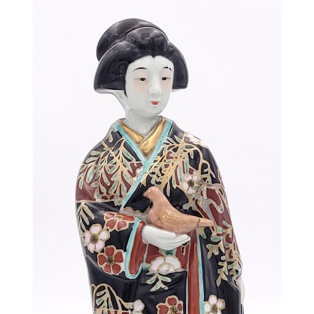 A Japanese porcelain Imari courtesan with dove, late 19th century circa 1880. Bird's tail restuck.
