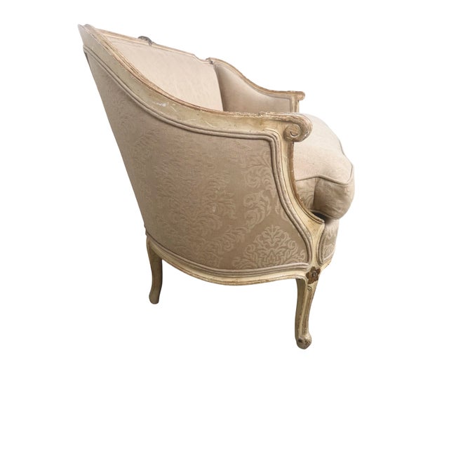 An elegant vintage Louis XV Revival settee featuring a carved giltwood frame, graceful cabriole legs, and softly curved...