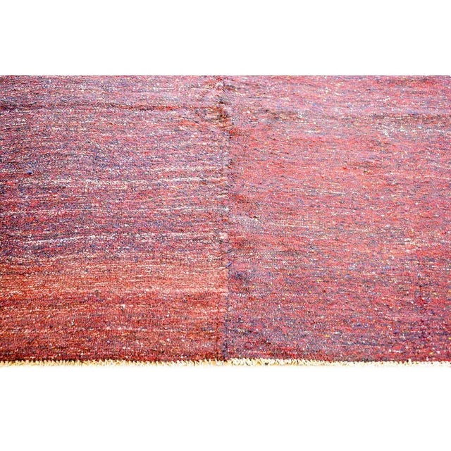 A brilliant vintage Persian Gabbeh Kilim rug woven in crimson and indigo wool with a wonderful stylized flower and simple...