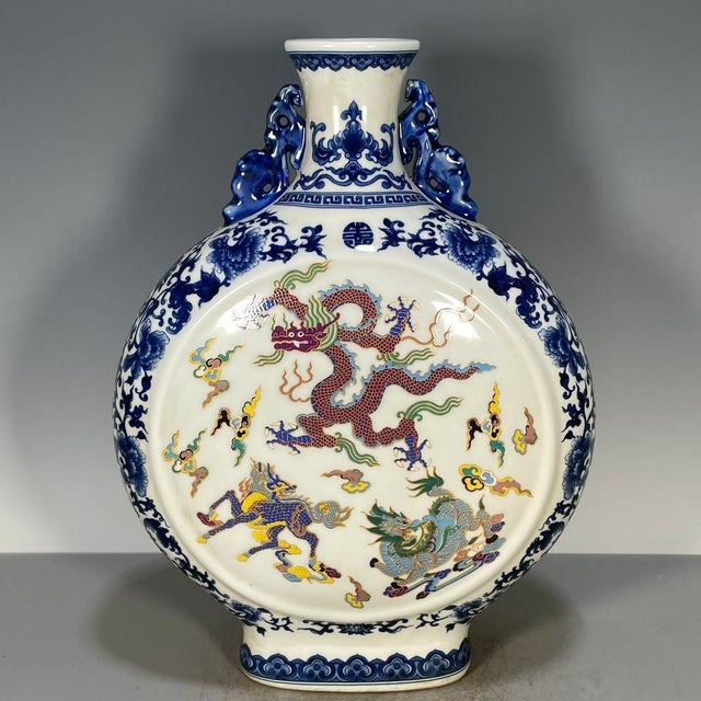 A striking Chinese porcelain moon flask (baoyueping). The vase features a flat, circular body with a short neck and...