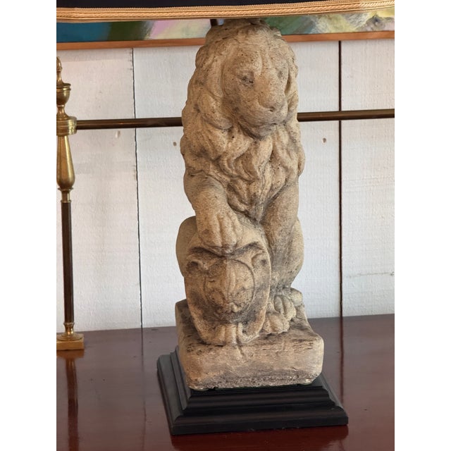 Matched pair of carved stone lion table lamps, the figures resting directly on separate square bases. Shown with dark...