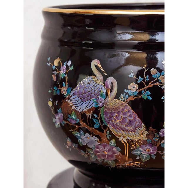 An elegant set consisting of a porcelain flower pot and a tall column base. The entire set is finished in black glaze with...