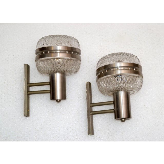 We offer a Pair of brushed Stainless Steel Sconces, Wall Lights with Cut Glass Globes made in Italy. In perfect working...