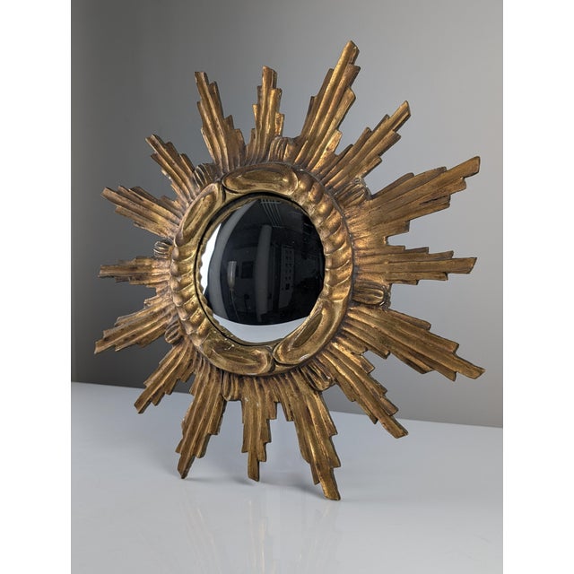 This sunburst mirror reflects the sculptural taste for radiating wall mirrors that became popular through the 1950s,...