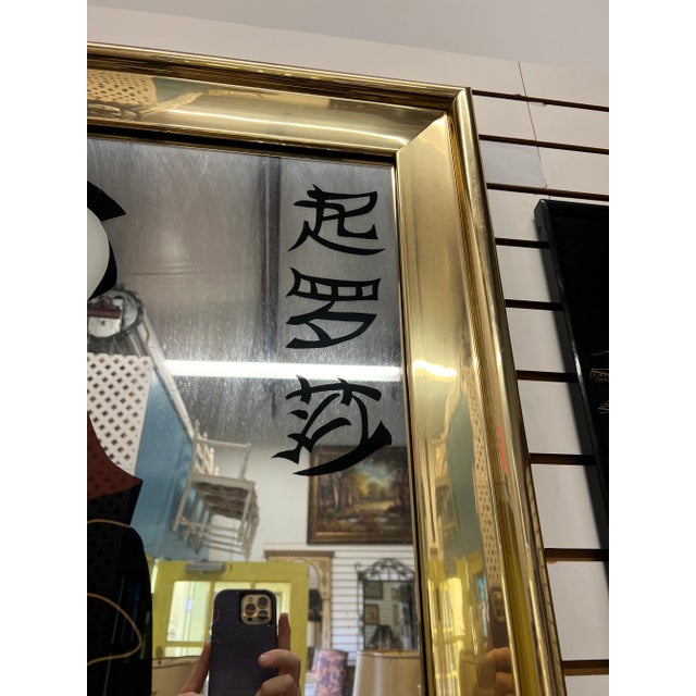 1980’s Large gold chrome framed mirror with an Asian flair. The picture of a gesha and her man seems to be painted on the...