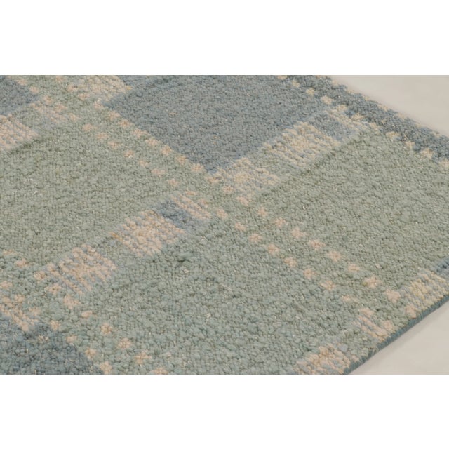 This 8x10 Scandinavian rug, handwoven in wool, showcases a playful checkered geometric layout rendered in green, blue, and...