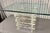 This is a 1970s vintage-style stacked lucite coffee table featuring a glass top and a base made of interlocking clear...