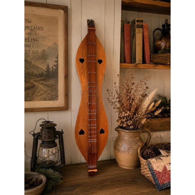A beautifully crafted vintage mountain dulcimer featuring a classic hourglass form with charming heart-shaped sound holes...