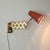 An elegant, adjustable vintage scissor wall lamp from the 1950s features a brass frame and a coral-red lacquered aluminum...
