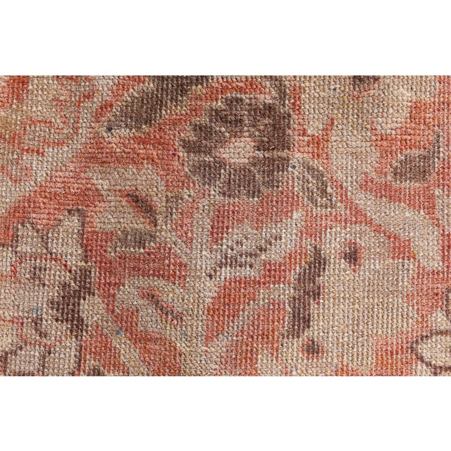 A Persian Tabriz carpet, the pale dusty rose field with a dense floral motif pattern surrounding a central beige medallion...