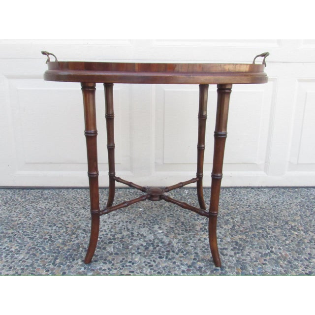 Antique English mahogany tray table, c.1920 An antique oval tray, inlaid with a conch shell, with two brass carrying...