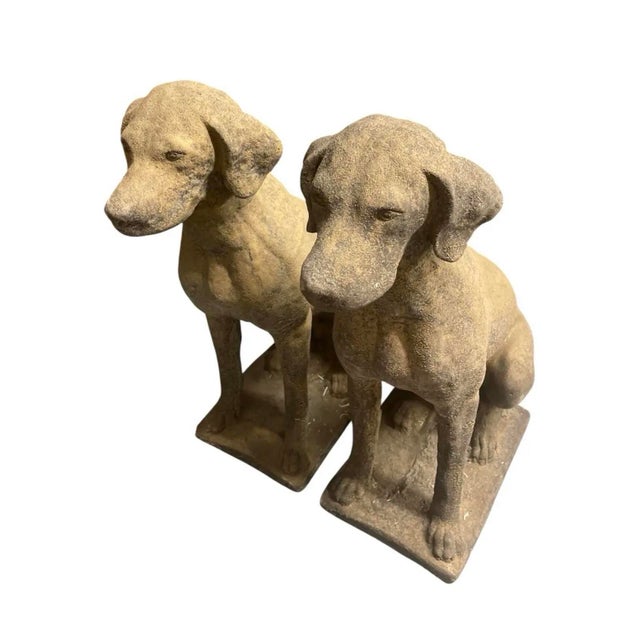 An exceptional pair of vintage mid-20th-century cast stone garden statues depicting seated hunting hounds, likely Pointers...