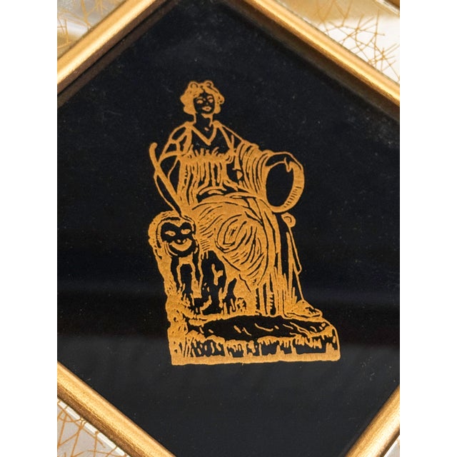 Striking pair of vintage mid-century Greco-Roman style wall plaques featuring black mirrored centers with elegant gold...