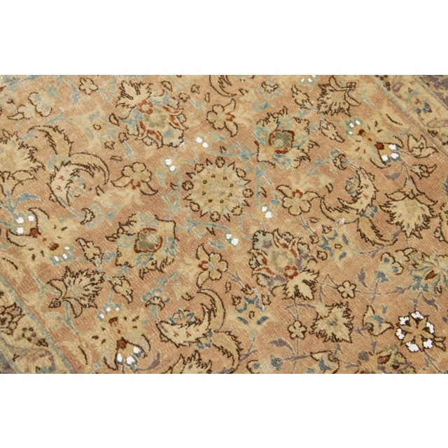 Beautiful Antique Kirman hand-knotted wool runner with a beige color field. This Persian rug has a blue frame and accents...