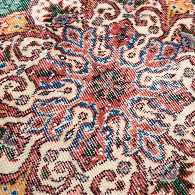 Elegant vintage Tabriz-style area rug featuring a rich deep green field centered by an ornate floral medallion. The...
