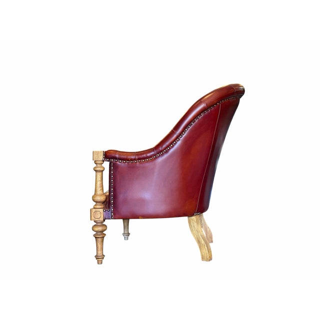 Vintage pair of burgundy tufted leather chairs featuring deep button tufting and richly patinated leather upholstery....