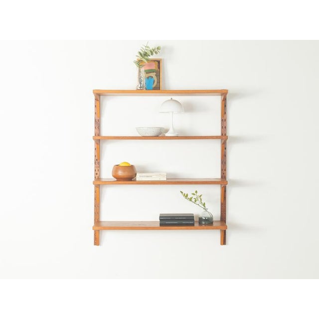 A classic wall shelf from the 1960s. The high-quality shelves are veneered in teak. The system consists of four shelves...