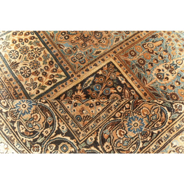 A Meshad (Meshed) carpet from Persia, having a garden-inspired design in rust-blue and deep walnut within the faded brown...