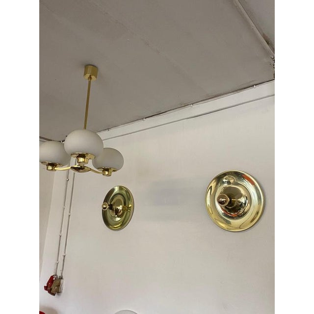 Set of 2 gold-colored discus lamps. These lamps were purchased by Charlotte Perriand for Les Arc’s Resort in the 1970s....