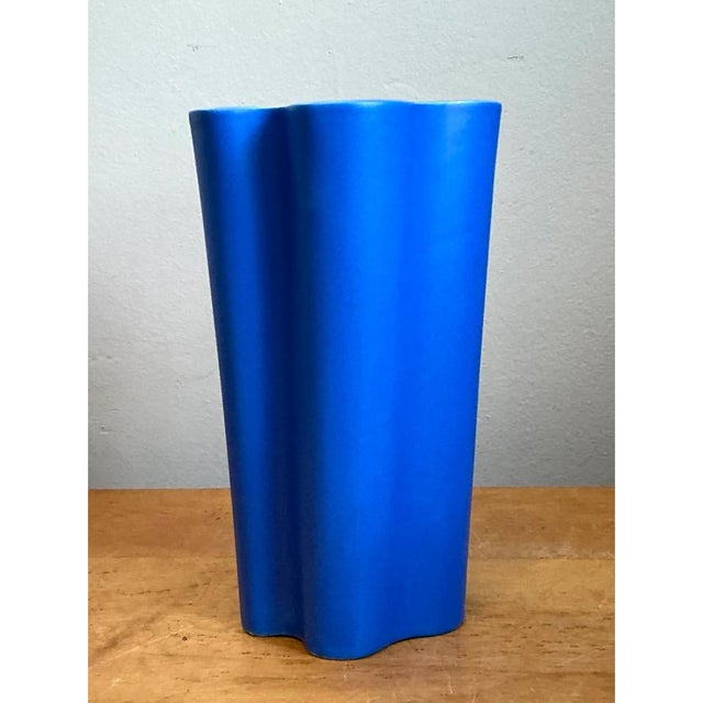 This vintage ceramic vase is a bold exercise in sculptural restraint, its tall, gently tapered body rising from a softly...