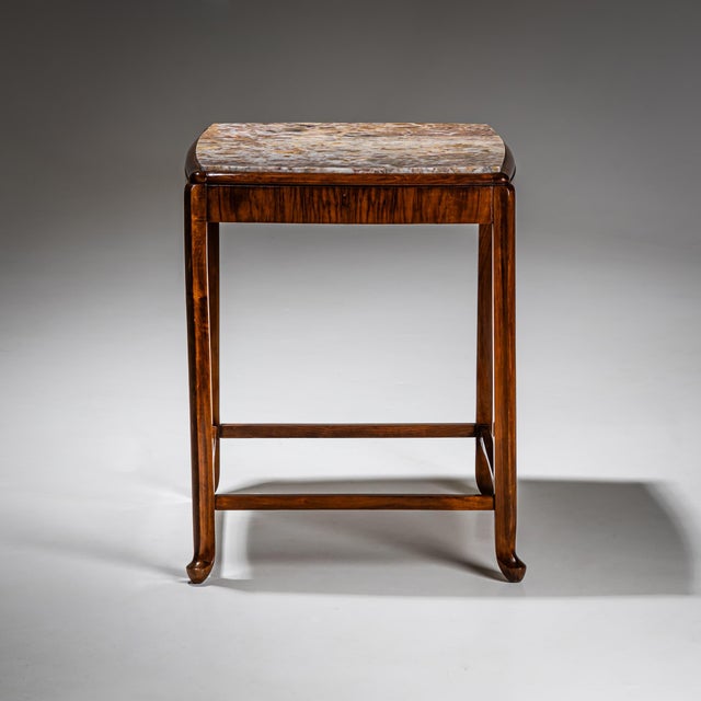 Side table with a mahogany frame on slightly splayed legs joined by straight stretchers. The gently convex top is inset...
