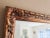 Vintage carved wood mirror finished in hand-painted gold gilt. Carved design features florals and beaded studs framing the...