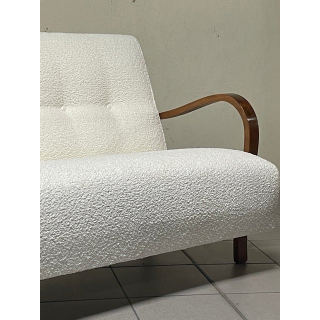 A 1940s-style two-seater sofa with an elegant and understated design, yet a touch of mid-century modern. The frame is...