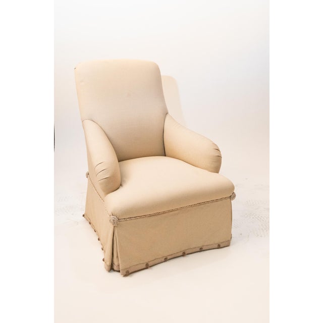 With high, tight back and seat; with straight skirt with inverted pleats at the corners; covered in a creamy beige silky...