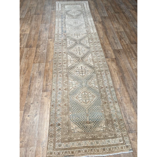 A stunning antique Malayer runner rug. This Malayer runner offers a beige and tan palette with brown and blue accents.