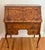 An antique French Provincial tiger maple slant-front secretary desk with applied cartouche molding, brass ring pulls,...
