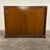 Mid Century John Widdicomb walnut sideboard or storage chest with sliding doors. The sliding doors feature recessed oval-...