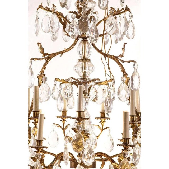 Exceptional French gilt bronze and cut-glass fourteen-light chandelier, the cage with faceted pendants. Measures: 125 x...